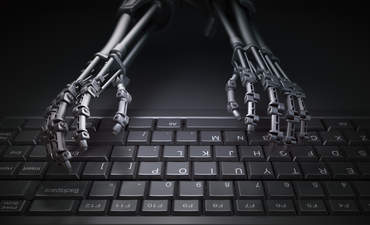 机械手在电脑键盘上打字，说明自动化和人工智能研究的概念