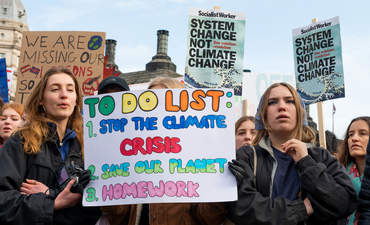 Student activists with placards at the February 2020 Youth Strike 4 Climate demonstration rally at Parliament Square, in protest of the government's lack of action on climate change in the U.K.
