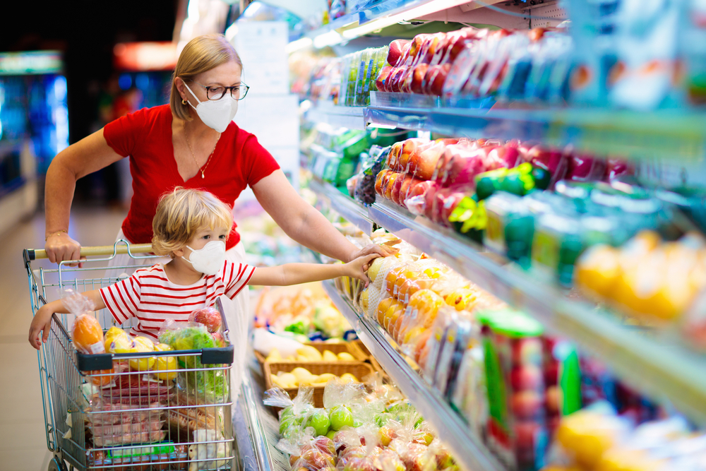 家长和孩子戴着医用口罩，而在超市购物的产品。