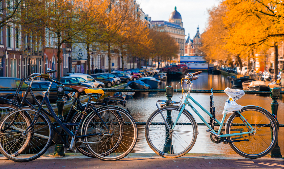 阿姆斯特丹运河Amstel与典型的荷兰屋，船屋和从小船的发光轨道在暮光之城蓝色小时，荷兰，荷兰。