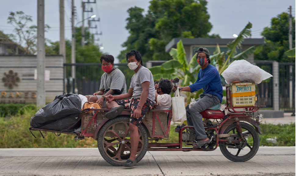 2020年4月，泰国巴萨姆他尼，骑着机动三轮车的回收者，戴着防护口罩。