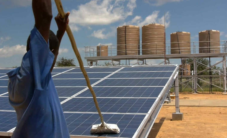 工人在Akutsima，纳米比亚脱盐设备清洁的太阳能电池板