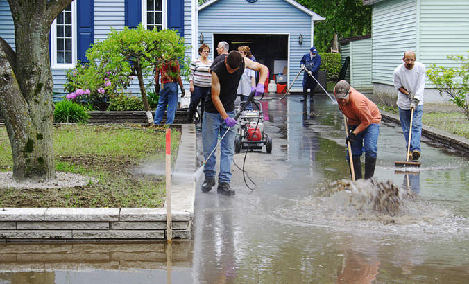 下面志愿者在加拿大魁北克洪灾郊区的家中清理外