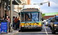 马萨诸塞州波士顿市，一辆在公路上与汽车并排放置自行车架的公共汽车。