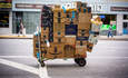 在纽约切尔西附近，一辆无人看管的手推车载满了来自亚马逊等公司的包裹
