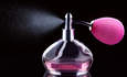 香水瓶喷洒亮粉色液体的图像