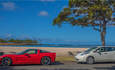 过去和未来?一辆红色跑车和一辆电动汽车开到海滩上……