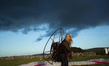 萨沙·丹奇，被称为“人类天鹅，”穿在她的背上一个动力伞。