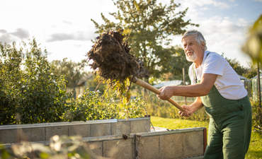 园艺工人在他的永久园艺花园里，使用再生土壤耕作
