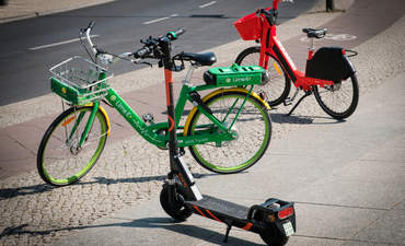 德国柏林人行道上出租的自行车和电动滑板车。