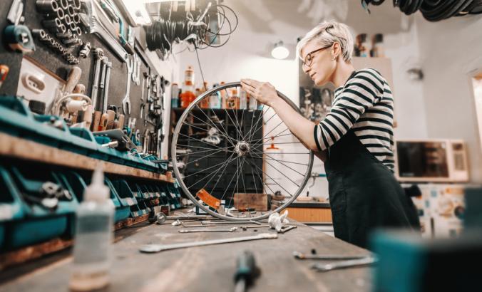 Person repairing wheel in bike shop