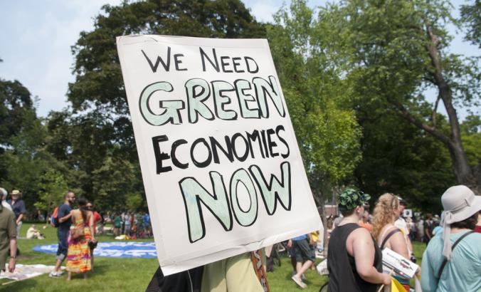 人们举着“我们现在需要绿色经济”的牌子