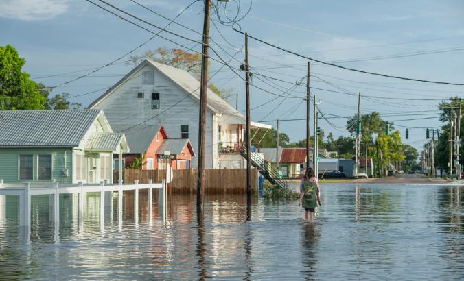 运河街在德尔坎布雷，在飓风劳拉期间。 Two people can be seen walking along the flooded roads in town as the storm surge subsides.