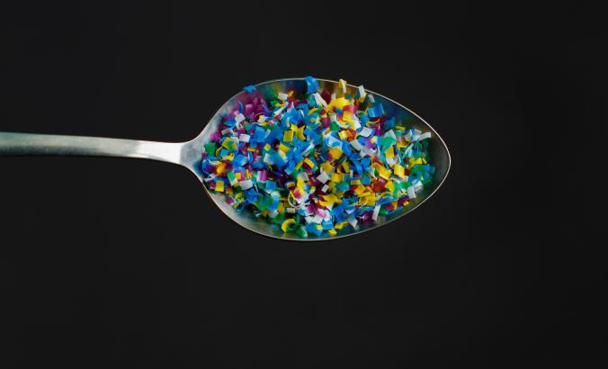Multicolored plastic pellets served on a spoon.