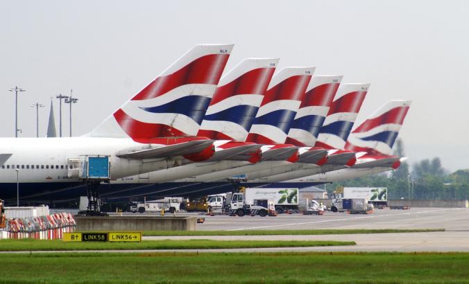 英国航空公司的波音747机队站在伦敦希思罗机场的停机坪上。飞机尾部悬挂着红、白、蓝三色的英国国旗。