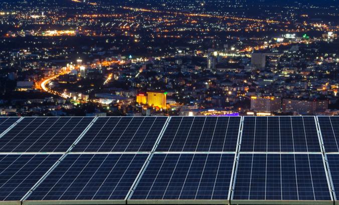 太阳电池板在晚上在一个城市。