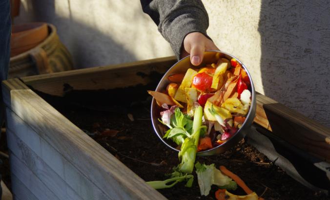 人们把碗里剩下的蔬菜扔到后院的堆肥里