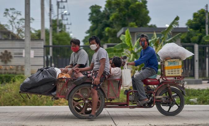 回收在马达三轮车的收藏家，佩带的防护面面具，在泰国派在Pathumthani，在2020年4月。