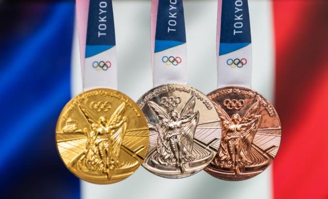 2020东京第三十二届夏季奥运会的金牌、银牌和铜牌，以法国国旗为背景。