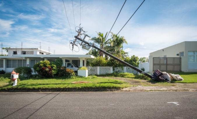 一根破碎的电话杆危险地靠近在波多黎各的圣胡安以外的房子。