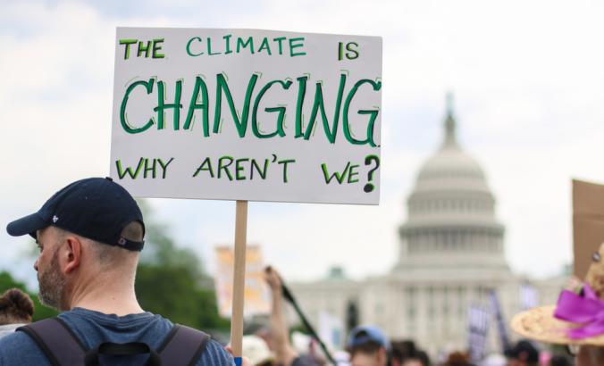 参加人民气候游行的成千上万人中有一个反对气候变化。他们的标志上写着：“气候正在发生变化。我们为什么不呢？