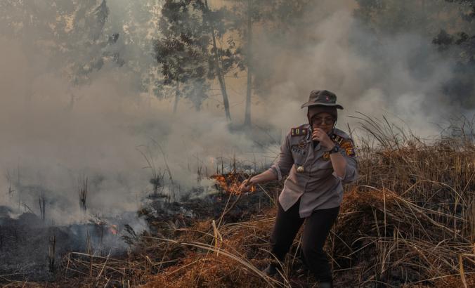 印度尼西亚消防员试图在瑞亚省Pekanbaru的Rumbai Puestir村灭绝泥炭兰湖