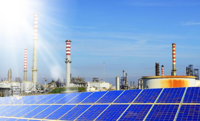 Solar panels with refinery in background“>
                  <div class=