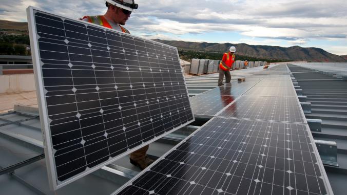 美国能源部(Energy Department)正在利用太阳能爱迪生公司(Sun Edison)和Xcel能源公司(Xcel Energy)签署的电力购买协议(Power Purchase Agreement)，员工们在这些电池板上工作。